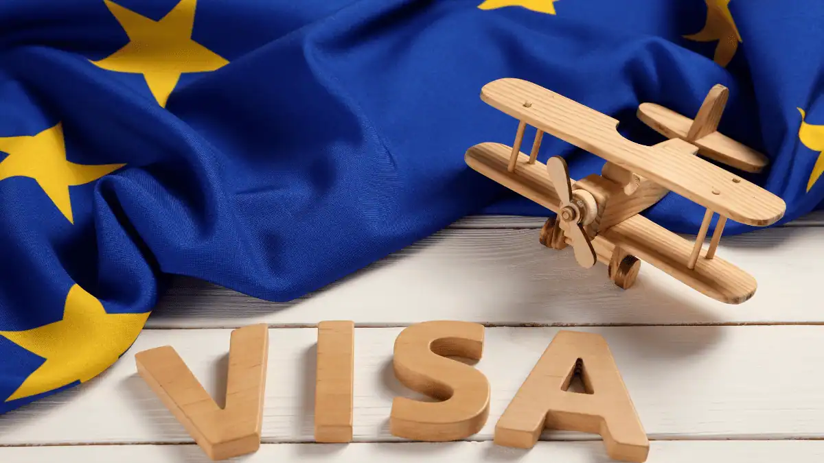 Visa Schengen : une nouvelle chance pour ces travailleurs ? Avion en bois avec drapeau de l'Union européenne en fond.