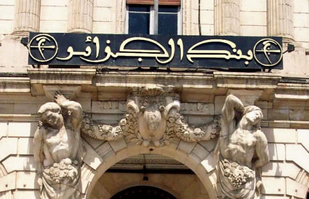 Découvrez l'outil révolutionnaire de l'Algérie contre les chocs pétroliers Façade d'un bâtiment historique avec sculptures et inscription en arabe.
