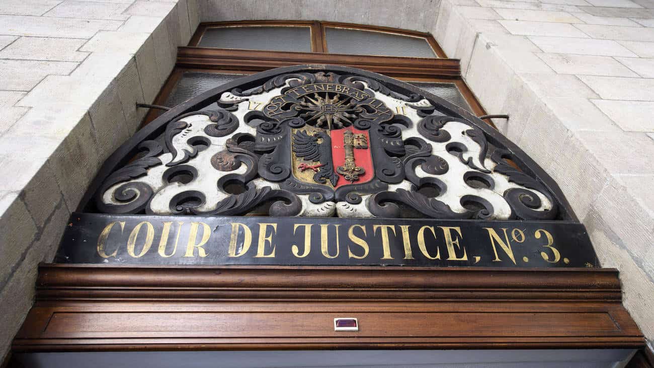 Entrée de la cour de justice avec armoiries et inscription.