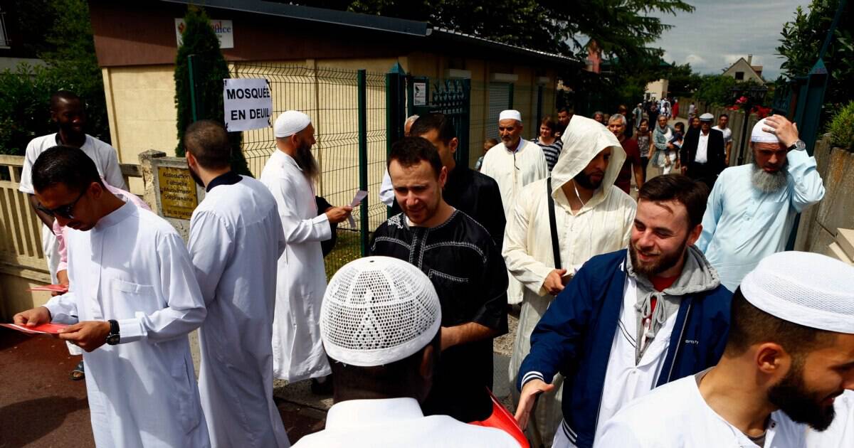 Groupe de musulmans en prière et en discussion en plein air.