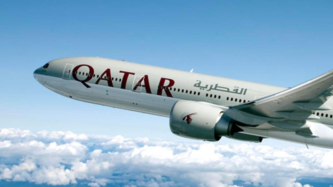 Avion Qatar Airways en vol au-dessus des nuages.