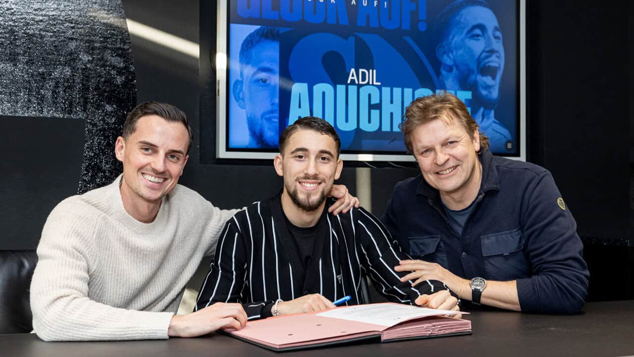 Pourquoi la pépite algérienne choisit l’Allemagne ? Trois hommes souriants lors d'une réunion professionnelle.