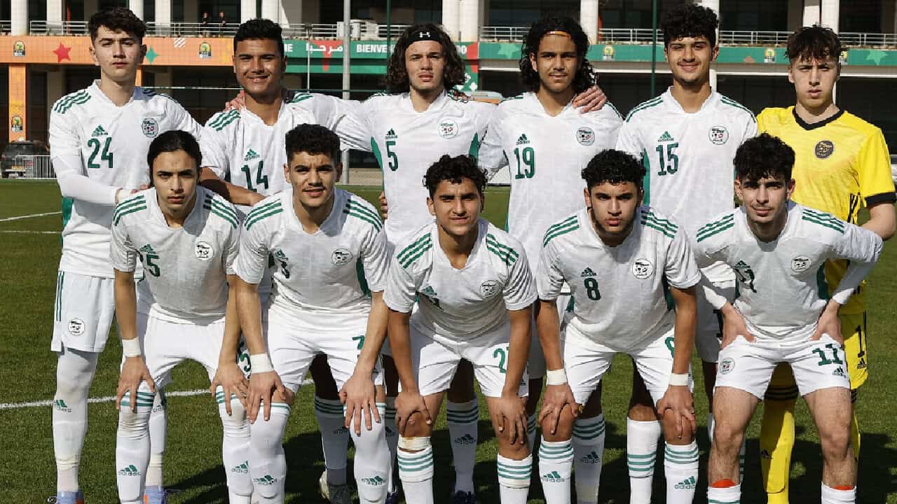 Algérie : une décision officielle qui va tout changer Groupe de joueurs de football algériens en uniforme blanc sur le terrain.