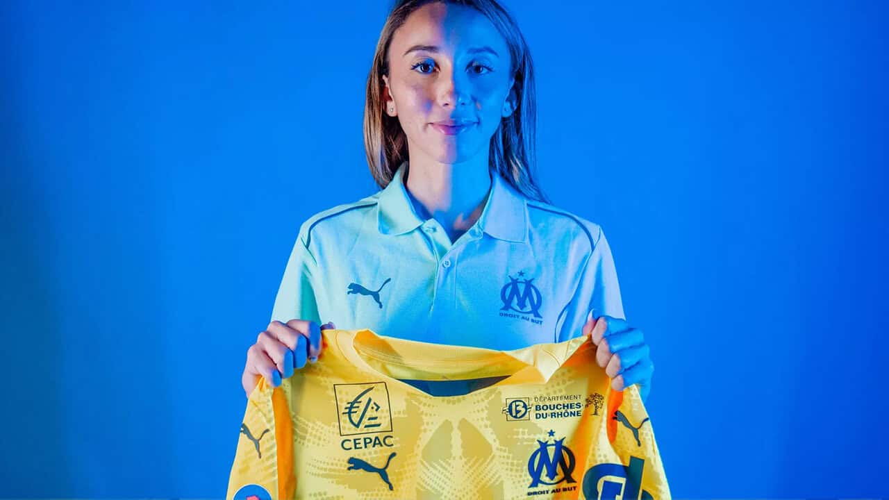 Jeune femme en maillot de football Olympique de Marseille.