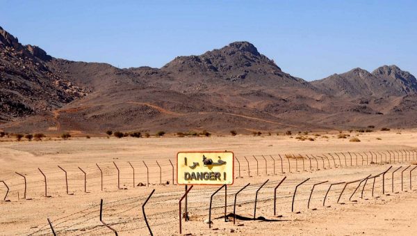 Nucléaire en Algérie : que cachent les sites décontaminés ? Zone désertique avec panneau de danger de radiation.