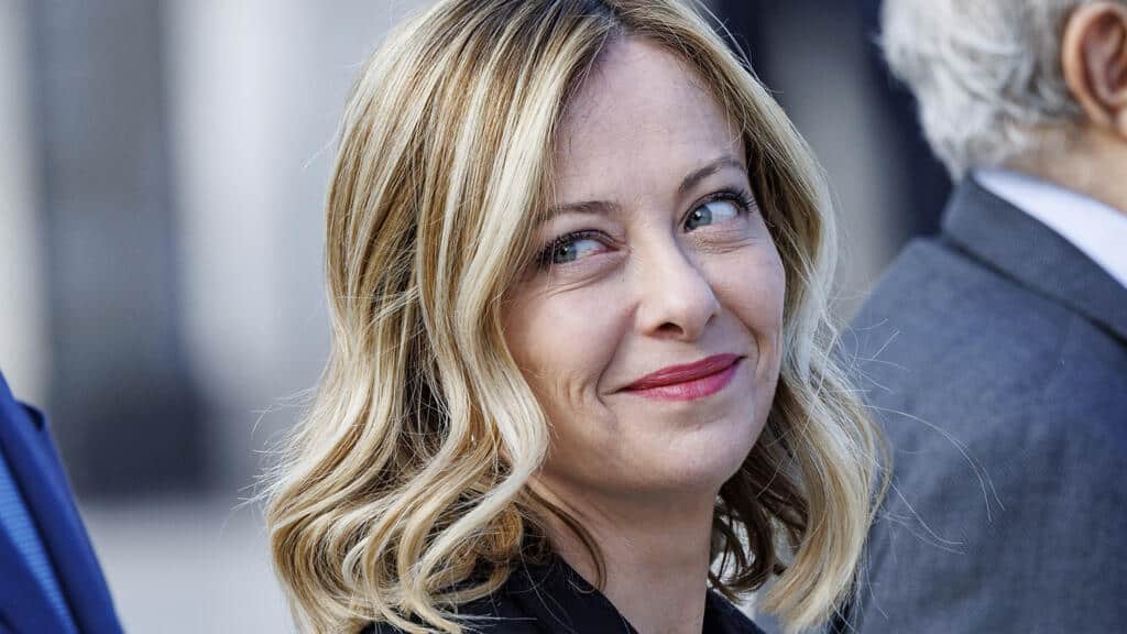 La colère de Giorgia Meloni : Découvrez l’affaire du migrant Giorgia Meloni souriante lors d'une réunion politique.