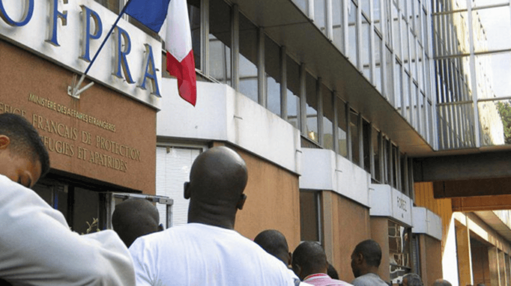 France : Nouvelles règles pour les demandeurs d’asile en 2026 Gens rassemblés devant une préfecture en France.