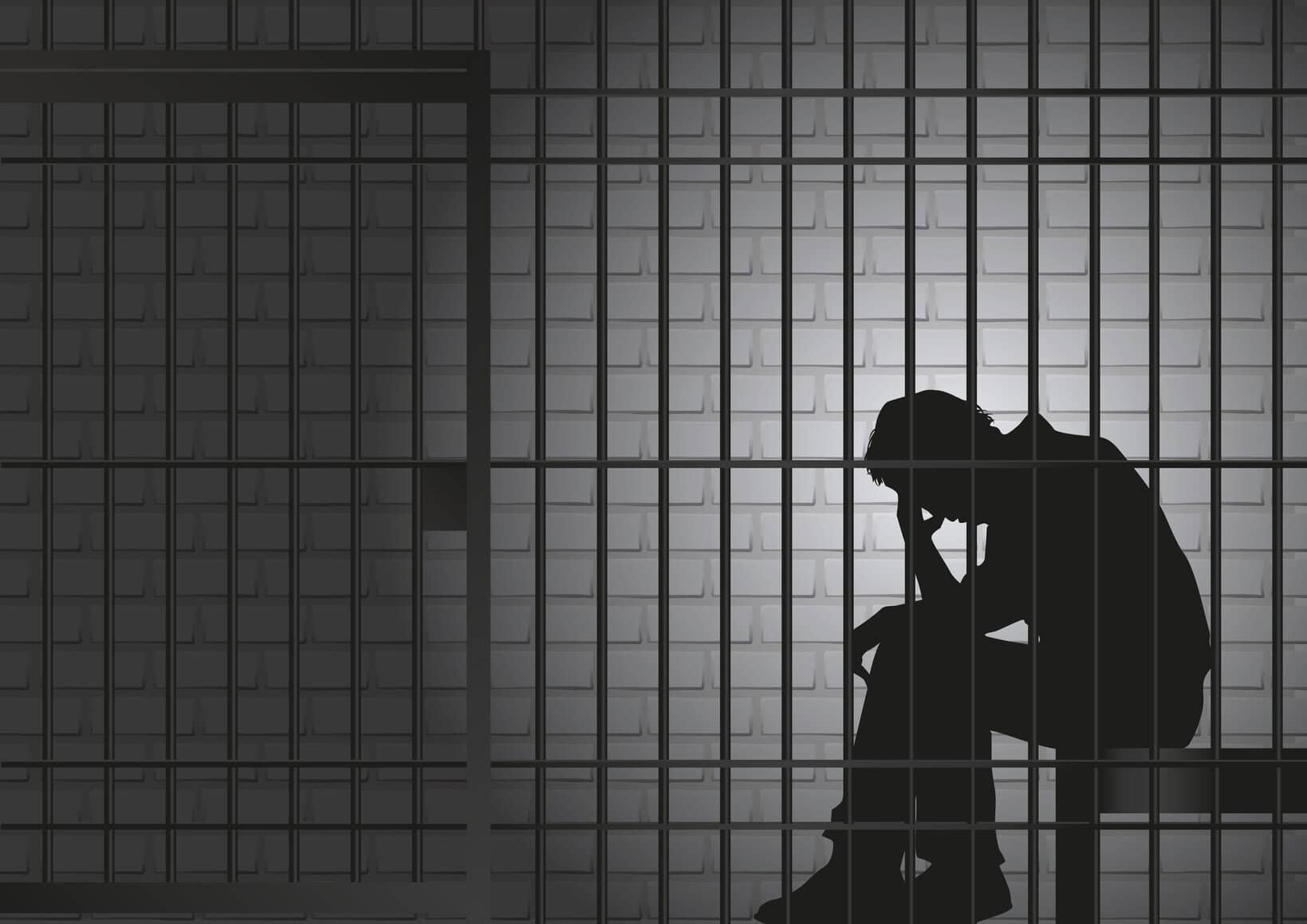 Personne en détention derrière des barreaux, silhouette sombre.