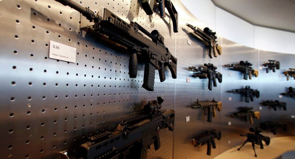 Vitrine d'armes modernes exposées dans un magasin d'armurerie.