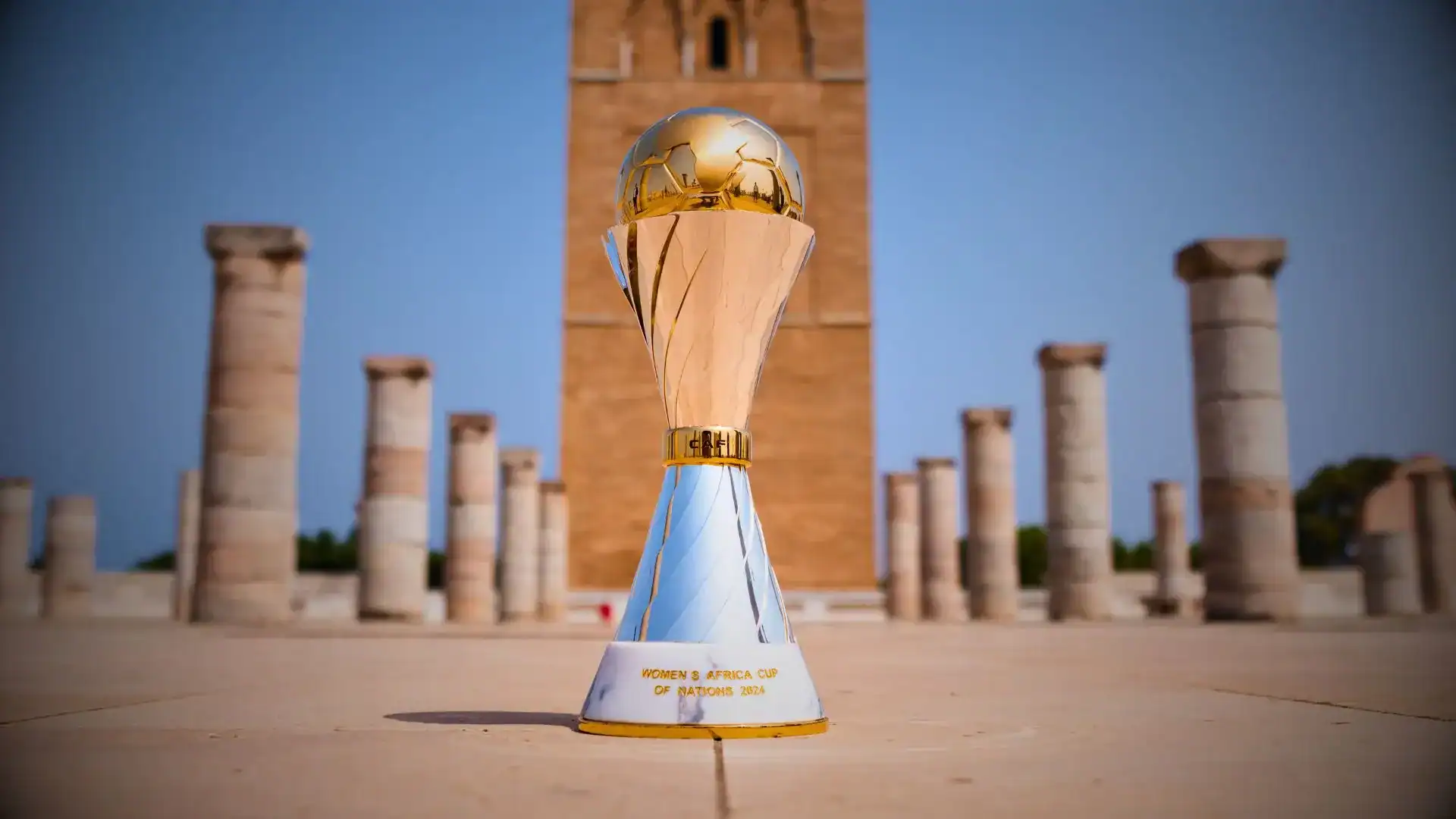 Rebondissement choc : le Maroc quitte la CAN 2024 Trophée de la CAN 2024 devant un monument historique marocain.