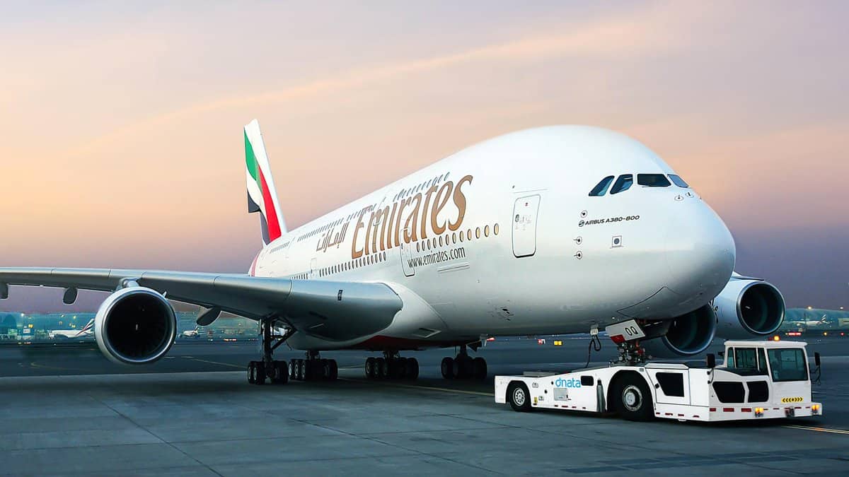 Emirates stoppe ses vols vers Alger dans une décision choc Avion Emirates blanc au sol avec logo et drapeau des Émirats arabes unis.