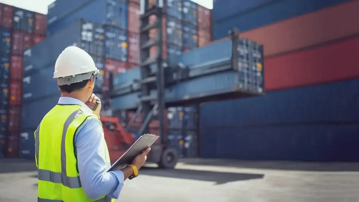 Agent de logistique surveillant le port avec un scanner.