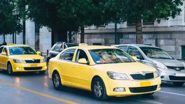 Taxis jaunes en circulation dans une rue d'Alger en 2026.