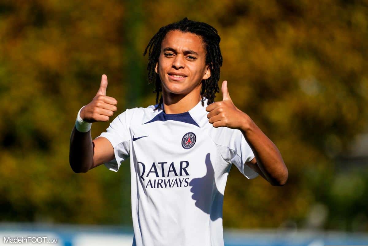 Ethan Mbappé en maillot du PSG, souriant et faisant un geste positif.