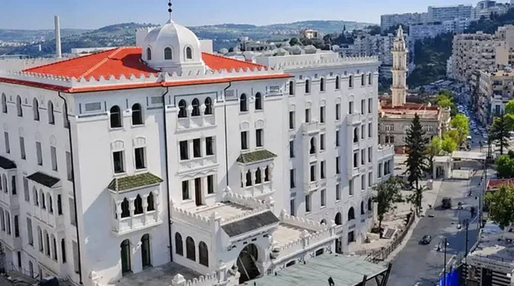 Vue aérienne d'un hôtel historique en Algérie avec architecture coloniale.
