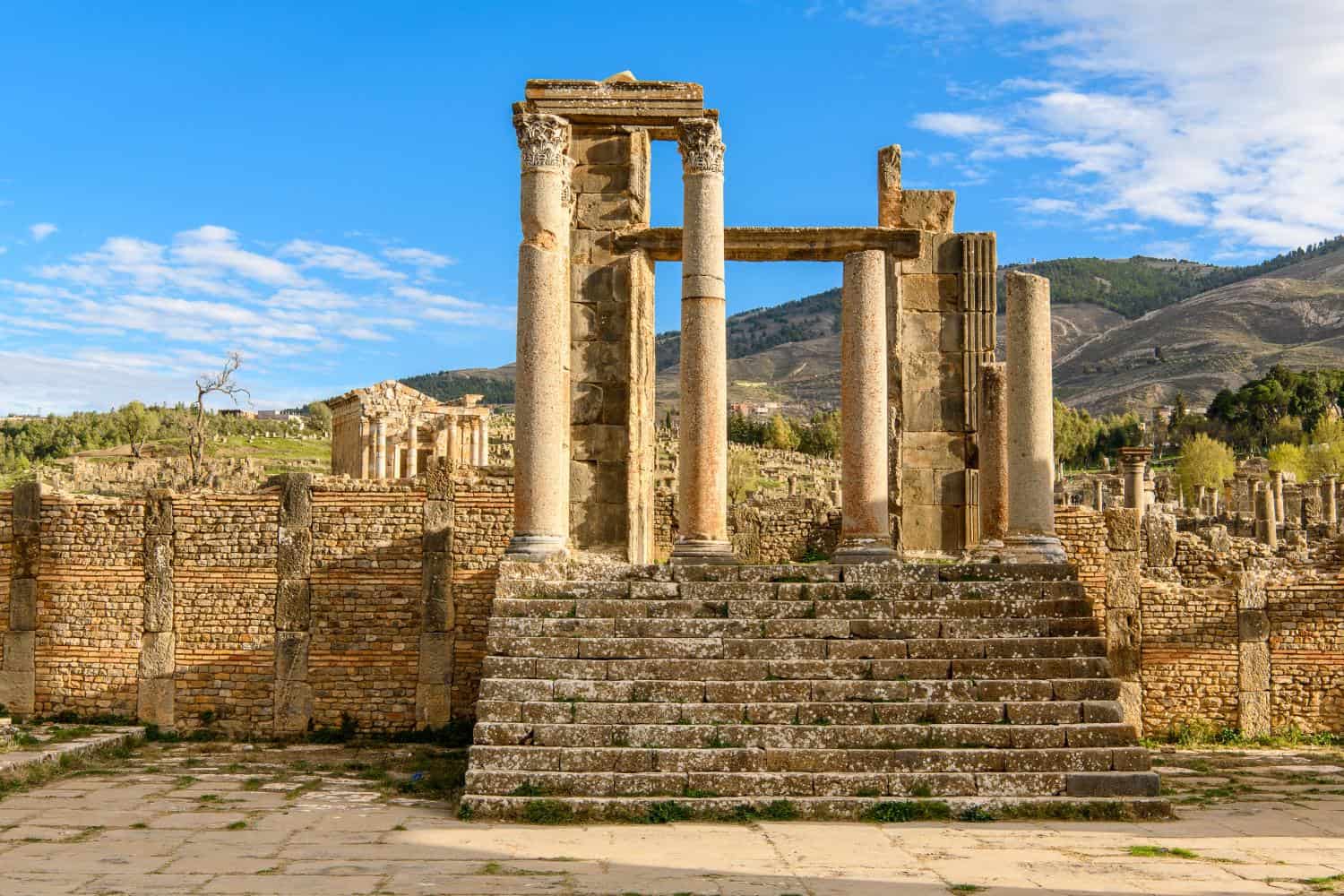 Ruines antiques de Djemila, site historique en Algérie, avec colonnes et escaliers.