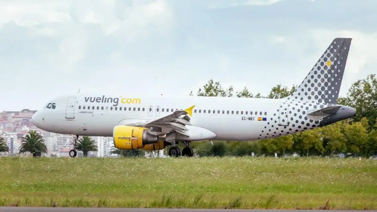 Avion Vueling avec logo jaune et gris en plein vol.