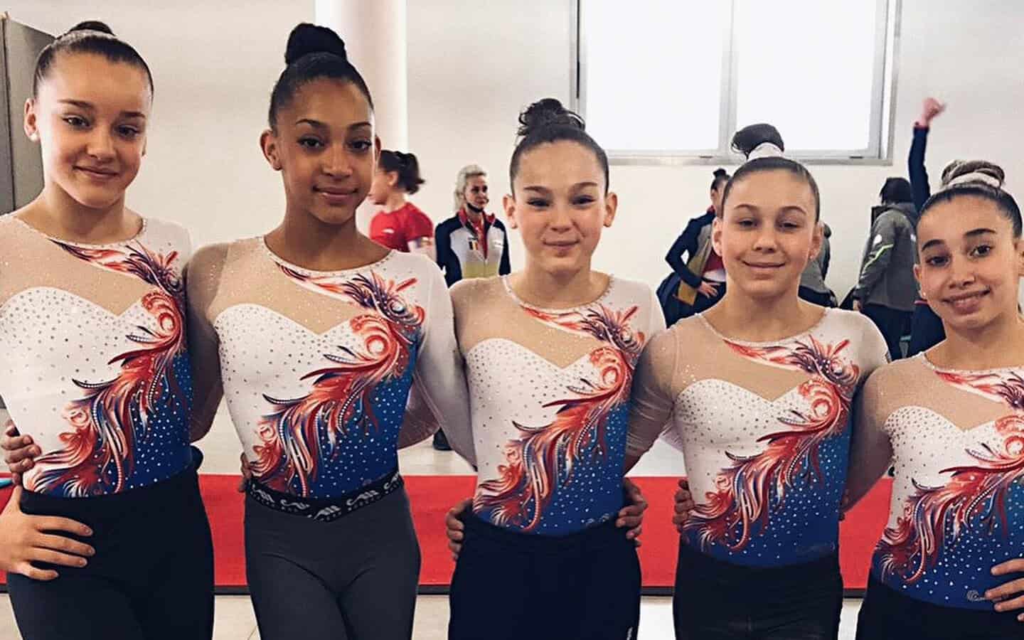 Groupe de jeunes gymnastes en tenue de compétition.