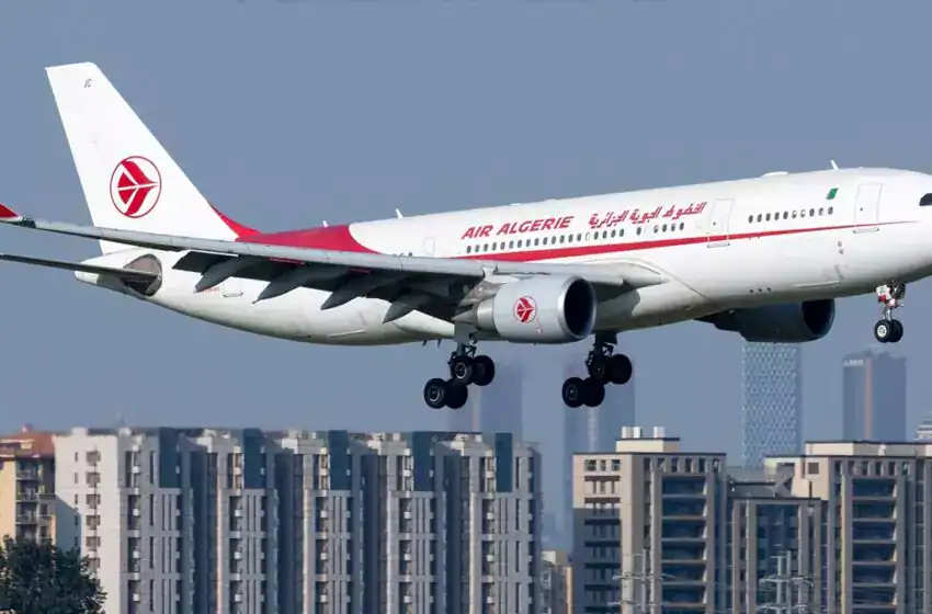 Avion Air Algérie en vol vers Alger Avion Air Algérie survole une ville avec des bâtiments modernes.