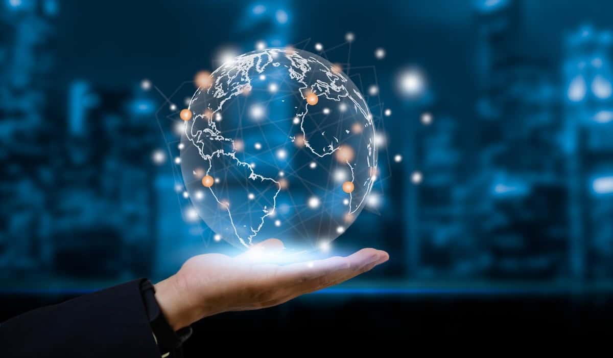 Main tenant un globe numérique connecté avec des réseaux mondiaux.