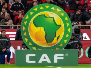 CAN : Un bouleversement inattendu annoncé par la CAF Logo de la CAF avec un globe africain dans un stade rempli de spectateurs.