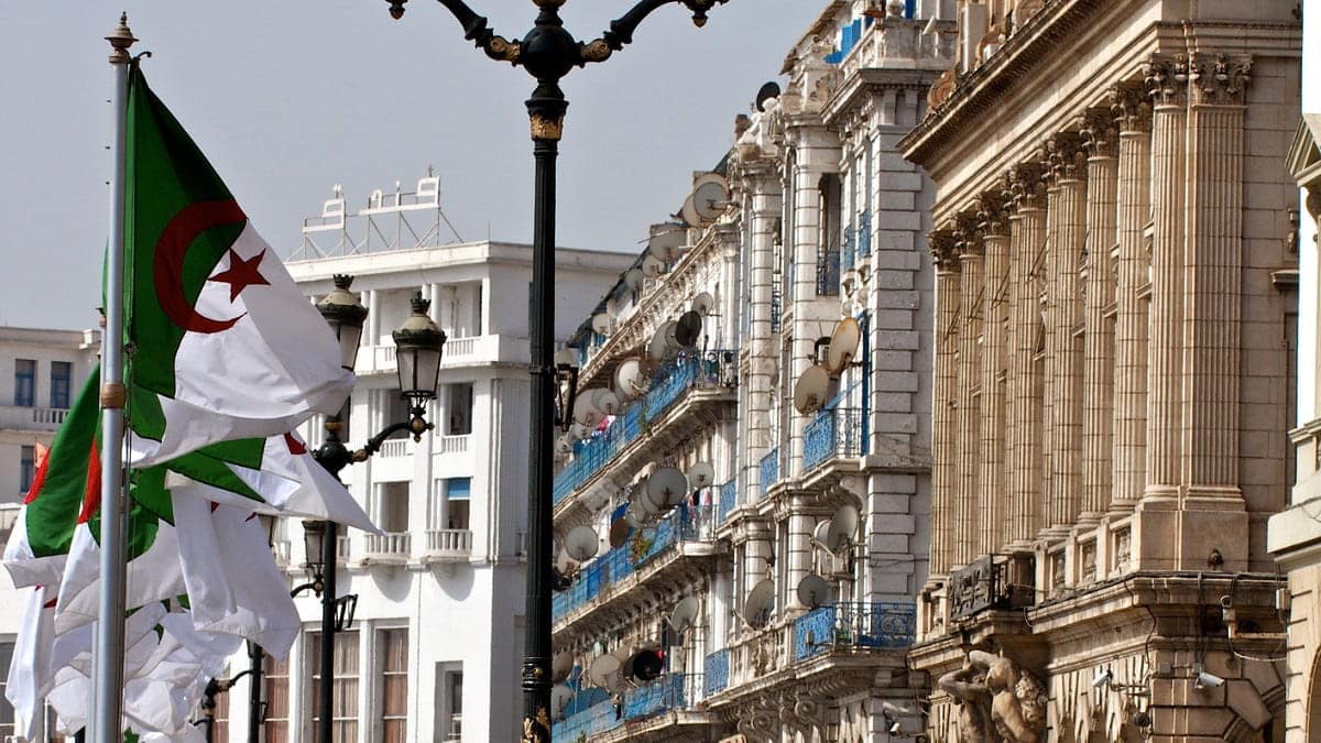 La République s’implique sur 1Tik : un tournant surprenant ! Drapeaux algériens flottant lors d'une manifestation dans une ville historique.