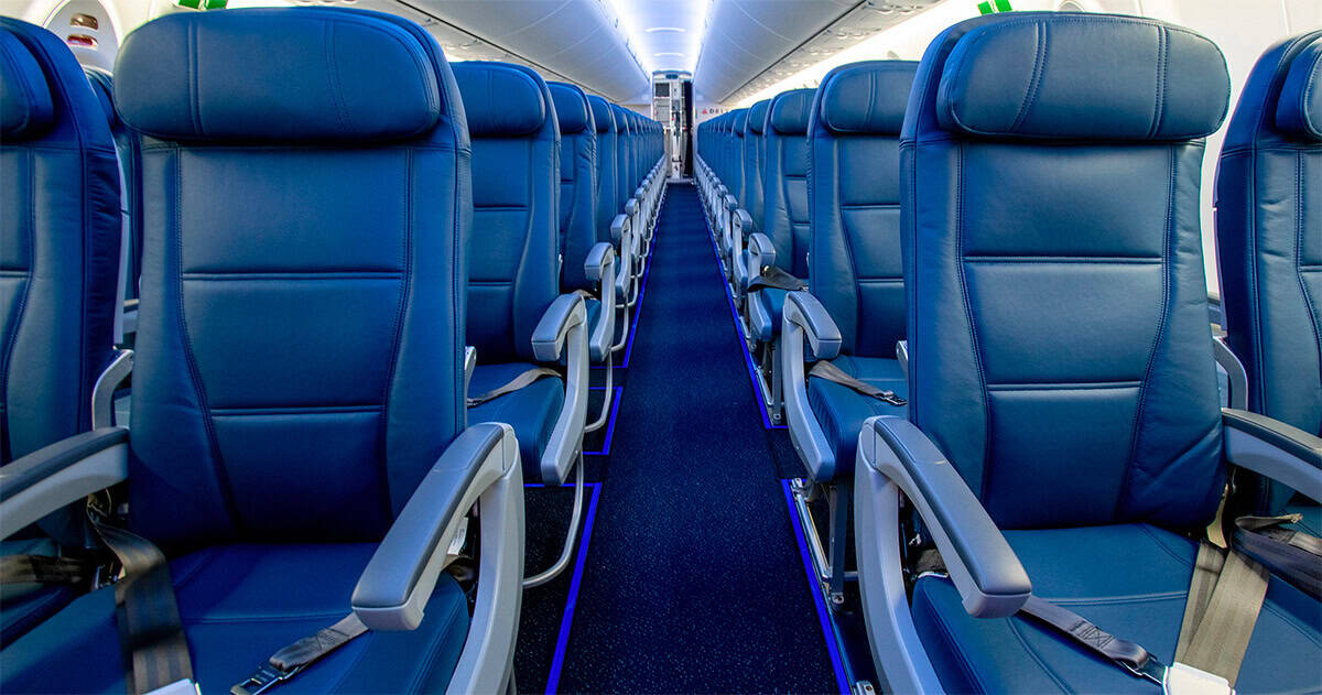 Découvrez comment les compagnies influencent vos réservations en classe éco ! Sièges d'avion en classe économique, rangée vide, intérieur moderne.
