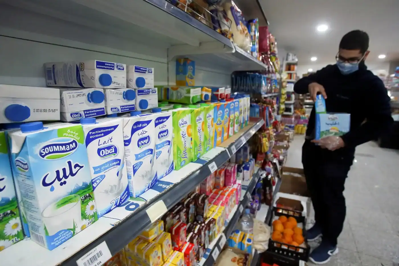 Client achetant du lait dans un supermarché en Algérie.