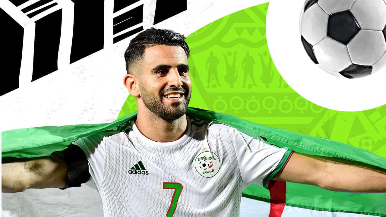 Riyad Mahrez avec le drapeau algérien après un but spectaculaire.