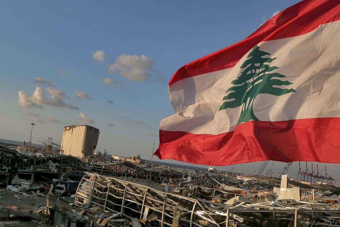 UNICEF : 10 enfants meurent chaque jour au Liban Drapeau du Liban flottant dans un paysage urbain dévasté.