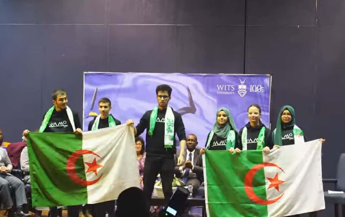 Jeunes prodiges algériens brillent aux Olympiades de maths ! Jeunes prodiges algériens avec drapeaux lors d'une cérémonie.