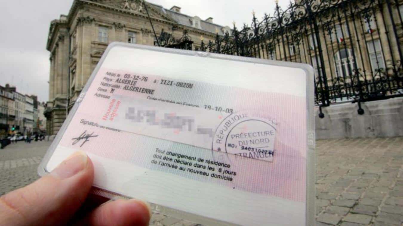 Piégé en Algérie depuis 2024 pour un visa périmé Passeport avec visa expiré devant un bâtiment officiel à Alger.