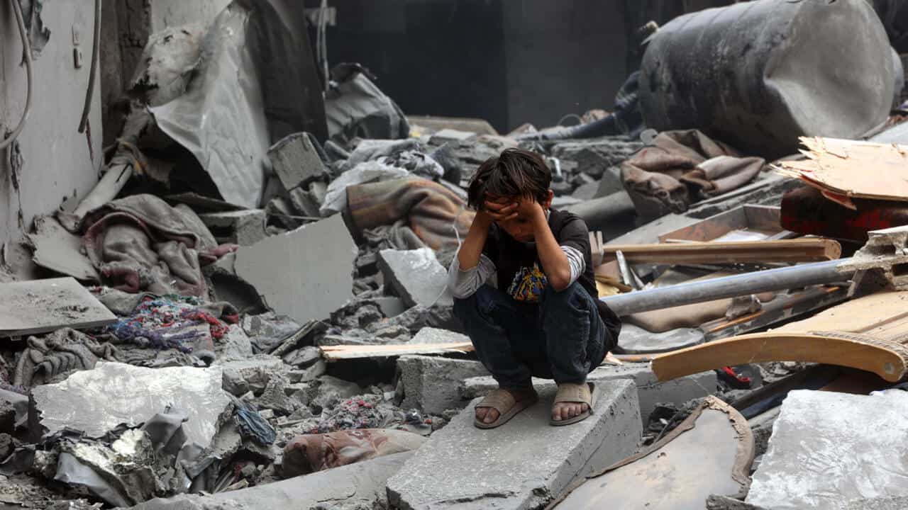 Incroyable tragédie : Ritaj, 9 ans, abattue en classe à Gaza Jeune fille assise parmi débris après attaque à Gaza.