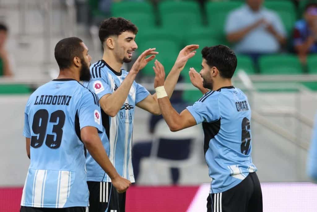 Un international algérien tape un chef-d’œuvre sur le gardien ! Trois joueurs de football en action lors d'un match, célébrant un but.
