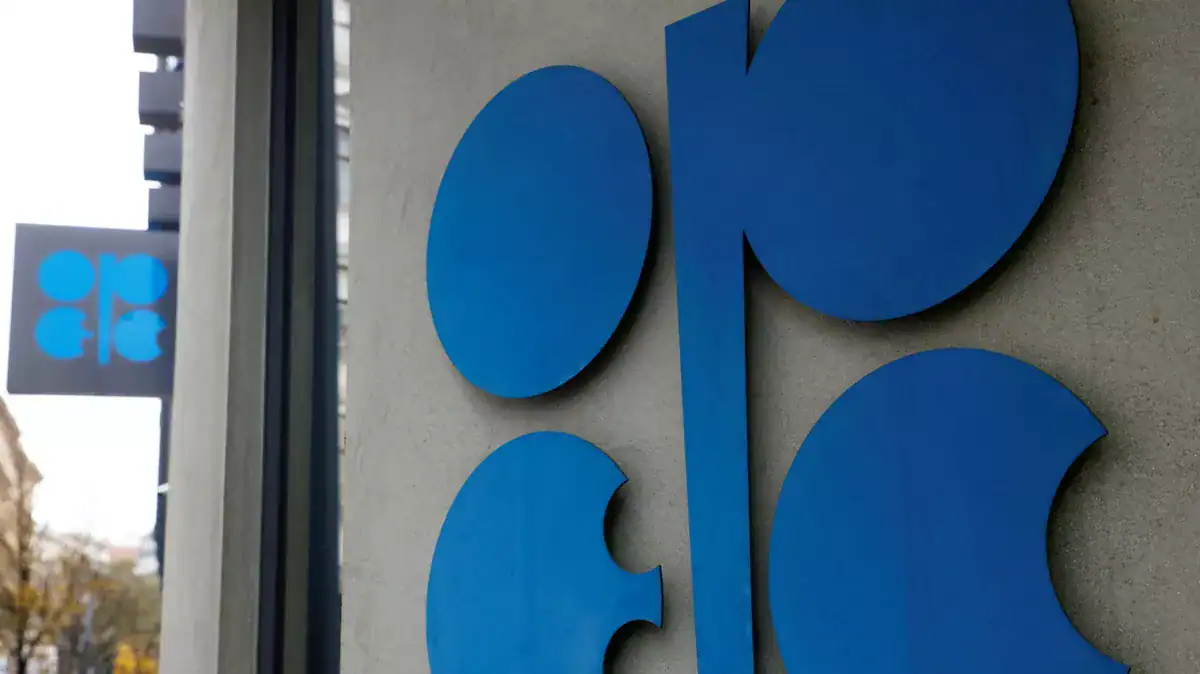 Logo de l'OPEP+ en bleu sur un mur en béton.