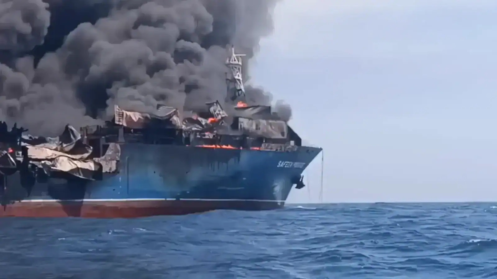 Vidéo : explosion de mines iraniennes dans des navires US ? Navire militaire en feu avec fumée noire dense s'élevant dans le ciel.