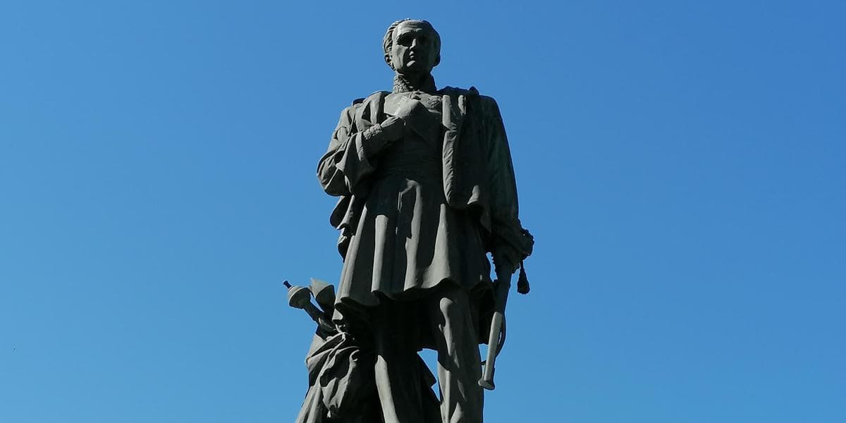 Pourquoi les statues de Bugeaud sont-elles controversées ? Statue de Bugeaud en plein air contre un ciel bleu clair.