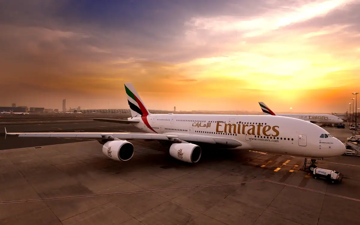 Avion Emirates sur le tarmac au coucher du soleil.