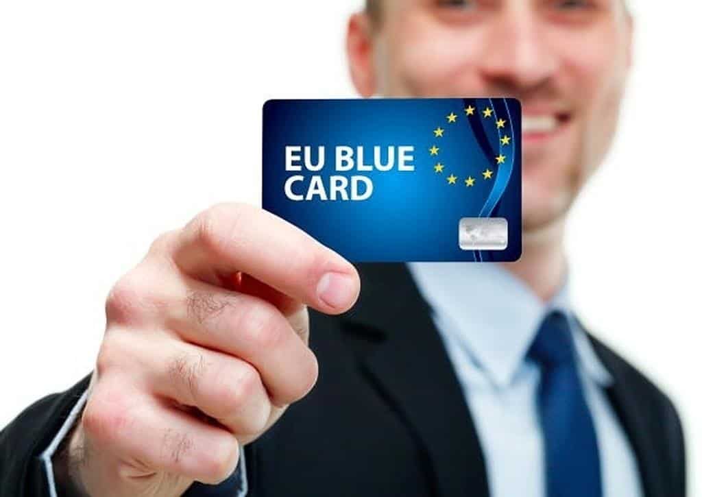 Algérienne en Europe : voici pourquoi elle n’a pas le mal du pays Homme tenant une carte bancaire EU Blue Card en main.