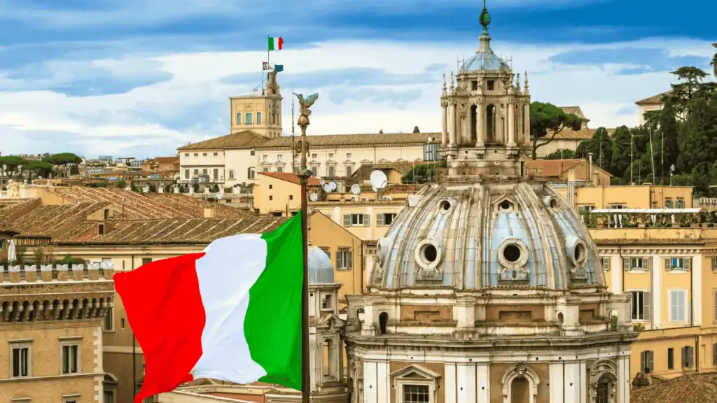 Algérie : l’UE capte 68 % des exportations, l’Italie devant Drapeau italien flottant avec vue sur Rome historique.