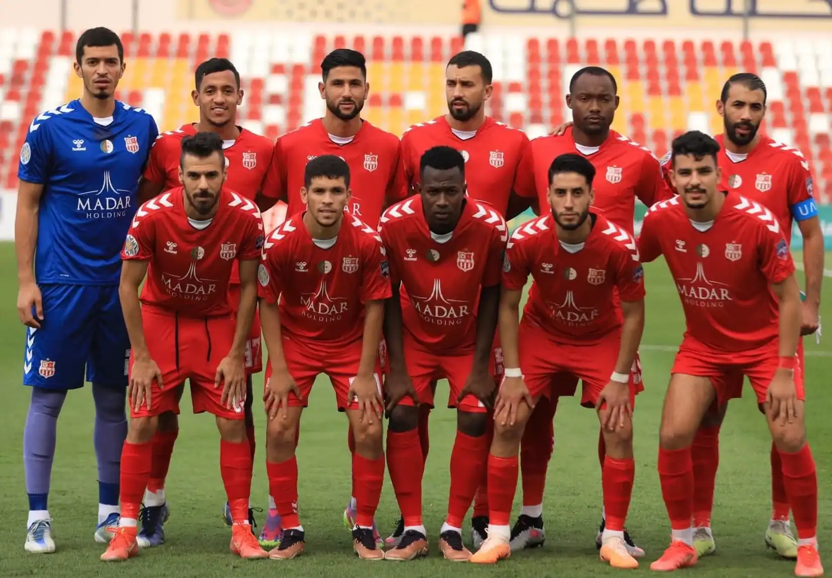 Équipe de football en préparation Groupe de joueurs de football en tenue rouge sur le terrain.