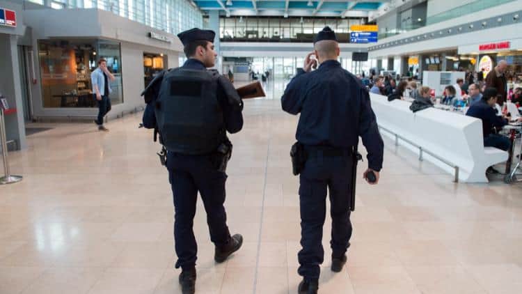 Algérien agresse un policier à Marseille : expulsion express Deux policiers marchant dans un aéroport bondé en France.