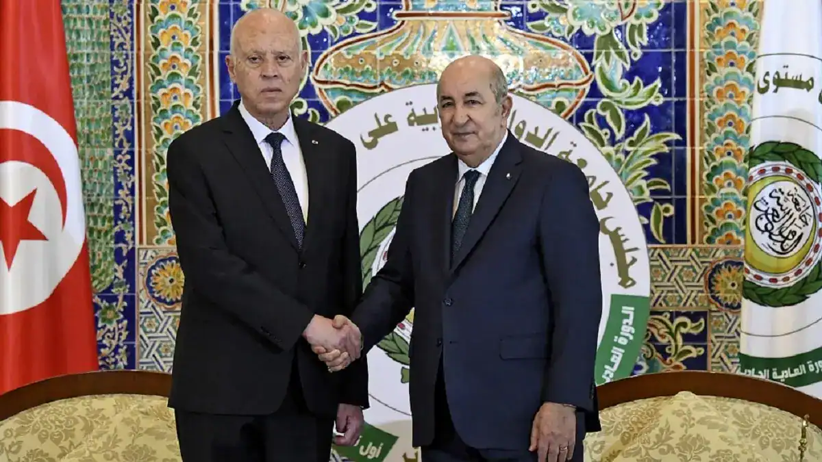 Algériens en Tunisie : ils dépassent désormais les Français en nombre Deux hommes en costume se serrent la main lors d'une rencontre officielle.
