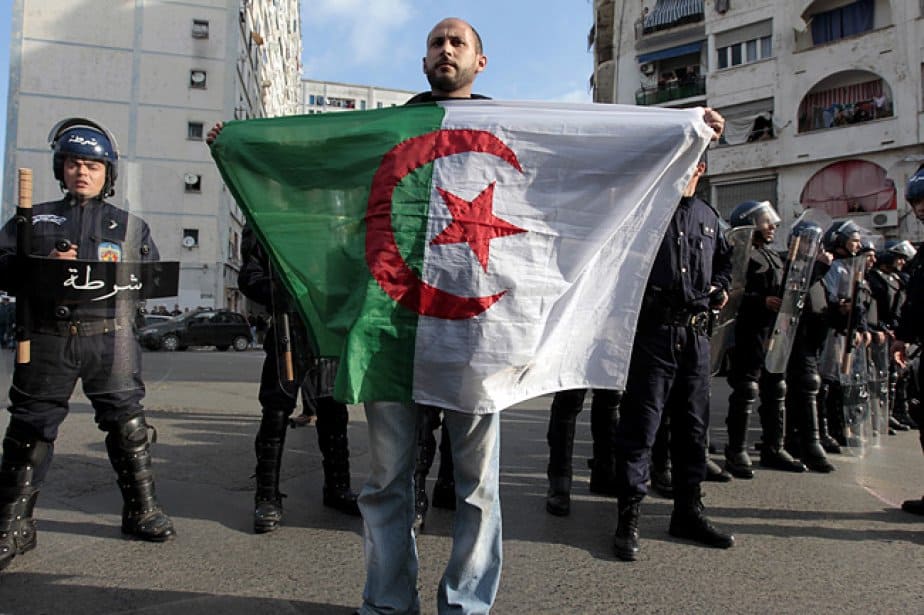 Algérie : le livre polémique de Xavier Driencourt fait réagir Homme tenant un drapeau algérien lors d'une manifestation à Marseille.