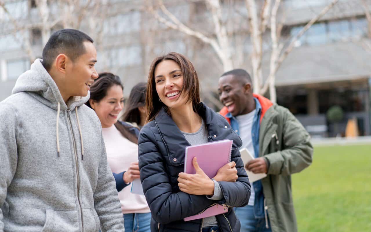 Étudiants étrangers : les nouvelles mesures en France Groupe d'étudiants étrangers souriants en extérieur en France.