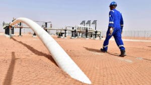 Réduction de 18% sur le GPL : Sonatrach innove en mai ! Technicien inspectant un pipeline de gaz dans un désert aride en Algérie.