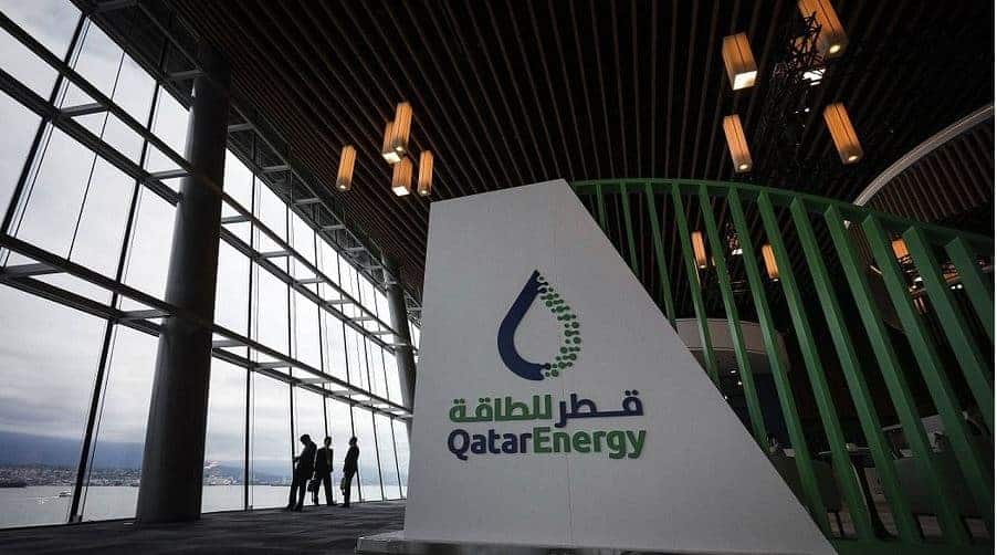 Qatar : prolongation de l’état d’exception pour le gaz Bâtiment moderne de Qatar Energy avec logo et vue sur l'intérieur.